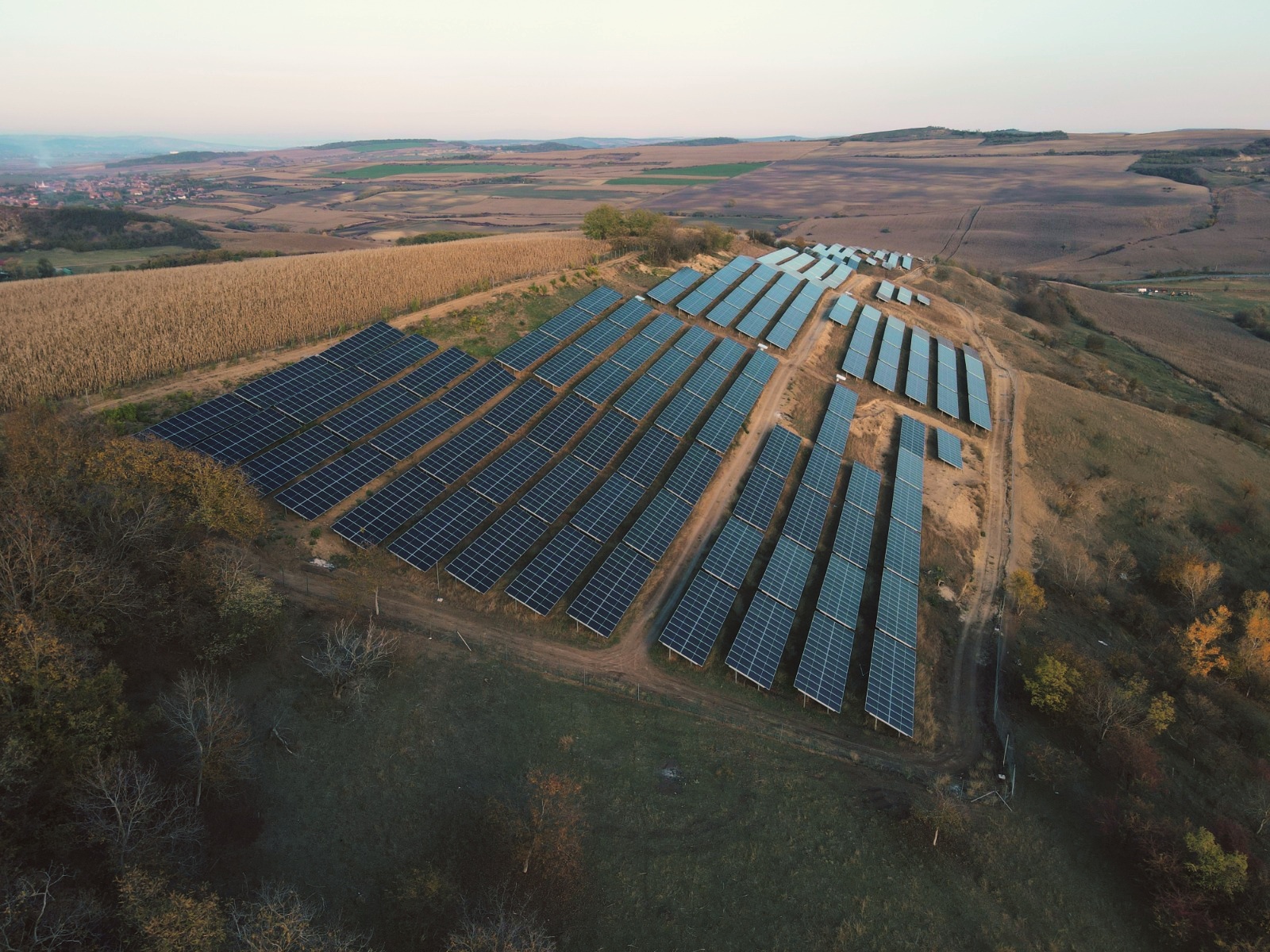 Vedere aeriană a unui parc fotovoltaic în mijlocul unui peisaj rural